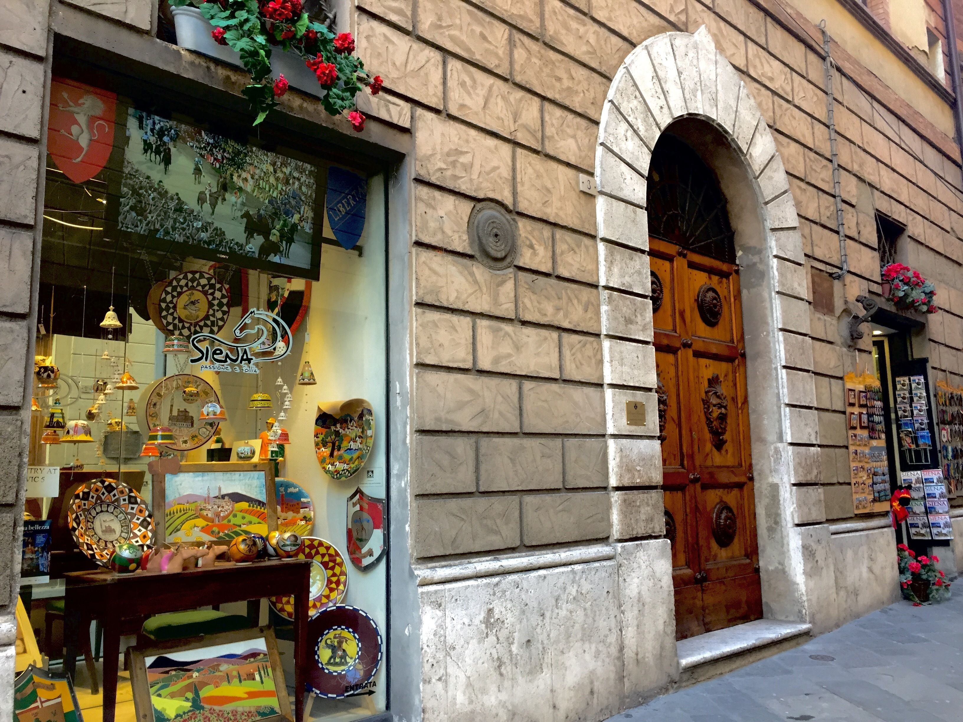 A storefront with a variety of decorative plates and a sign that reads "Siena".