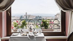 A table set for tea with a view of a cityscape through a window with curtains. - Residenza d'Epoca Palazzo Borghesi (Siena)