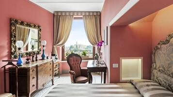 Una habitación de hotel con cama, una silla, cómoda, espejo y ventana con cortinas.