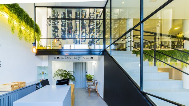 Een moderne hotel lobby met een receptiebalie, een trap en uitzicht op de bovenverdieping.