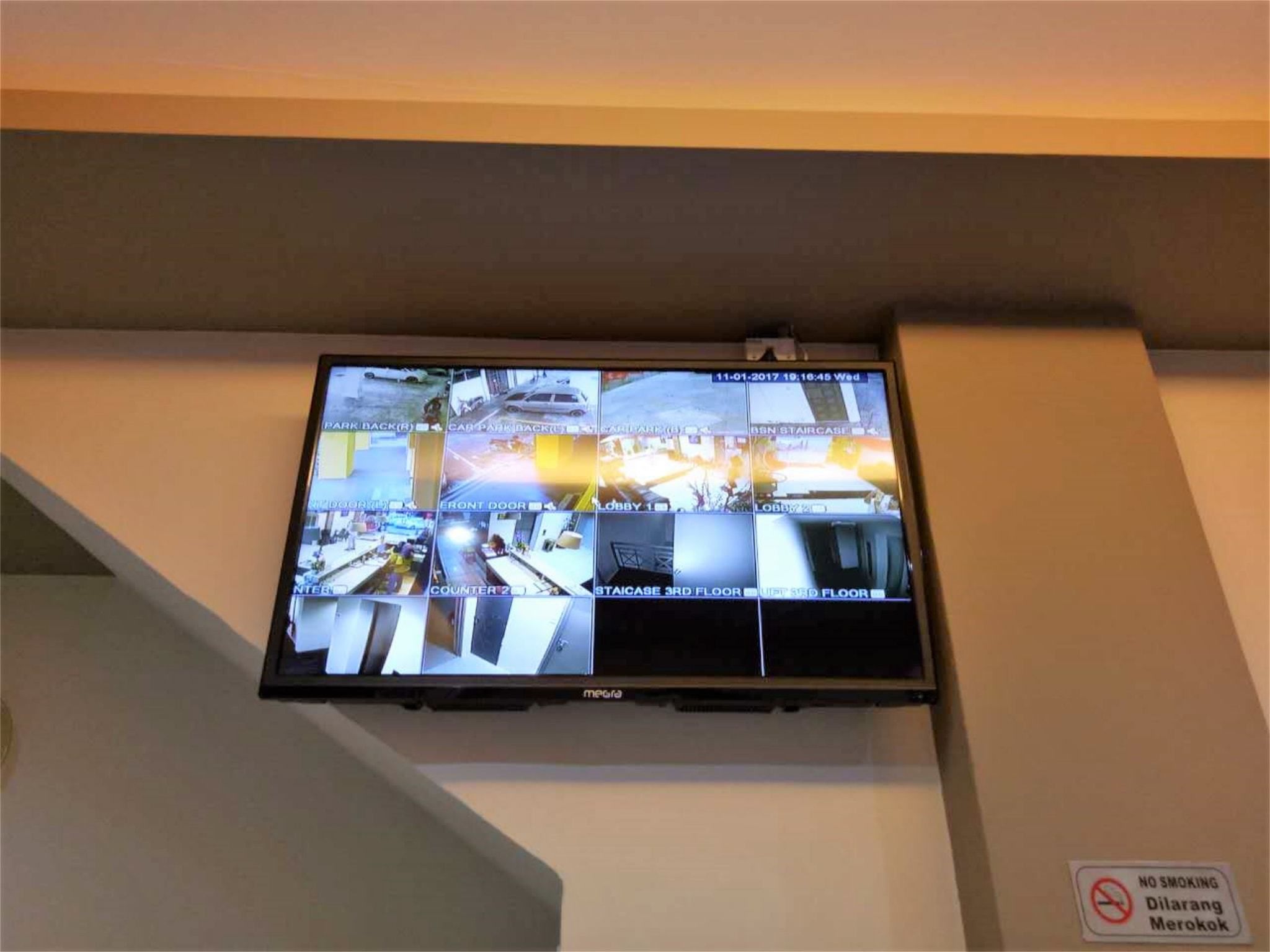 A security monitor displaying multiple camera feeds of a building's interior and exterior.