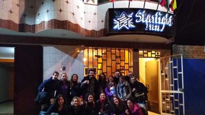 A group of people posing in front of a building with a sign that reads "StarLight Inn."