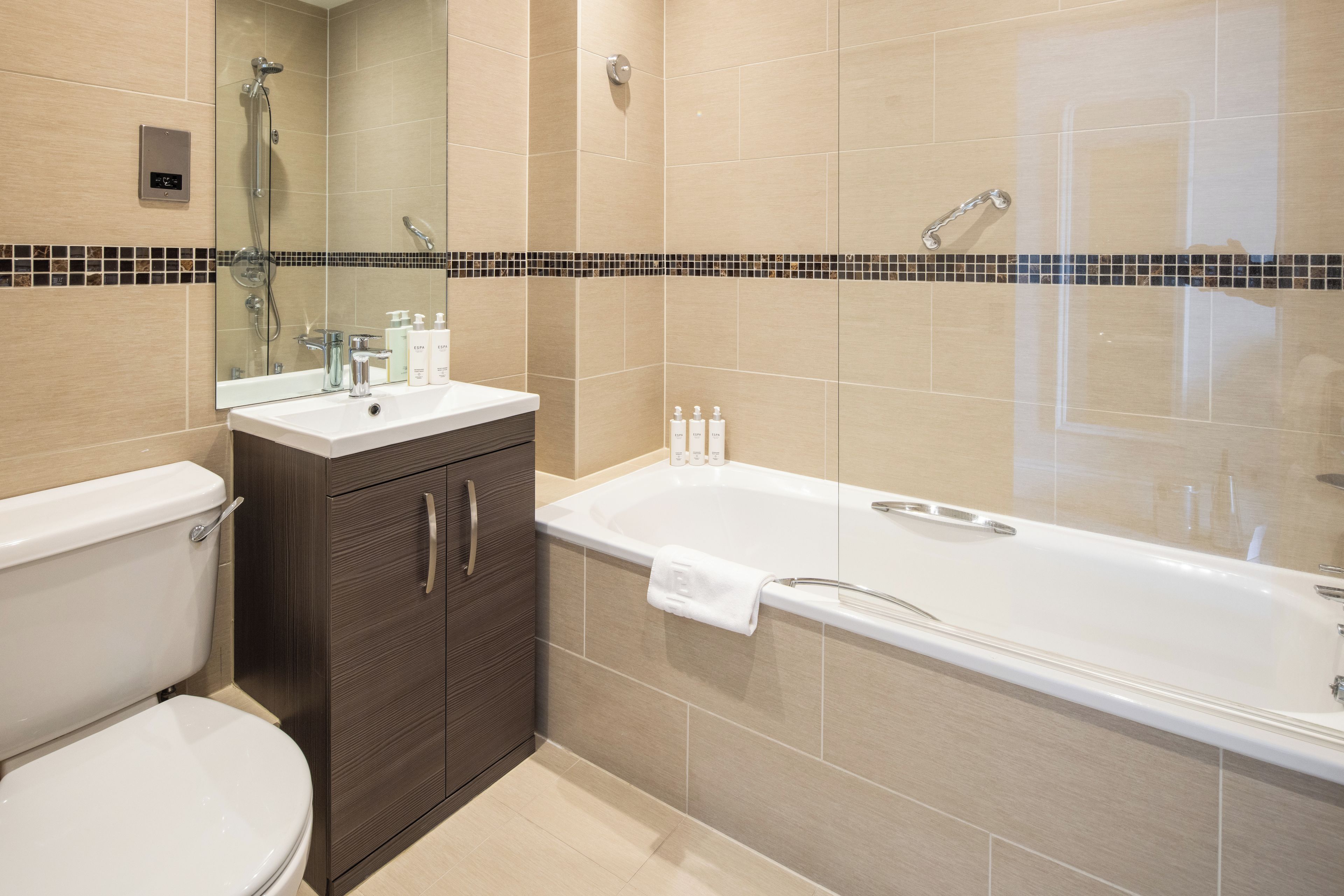 Un baño moderno con bañera, inodoro y tocador.