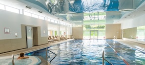Relax by the pool in a serene atmosphere, surrounded by lounge chairs and a modern design.
