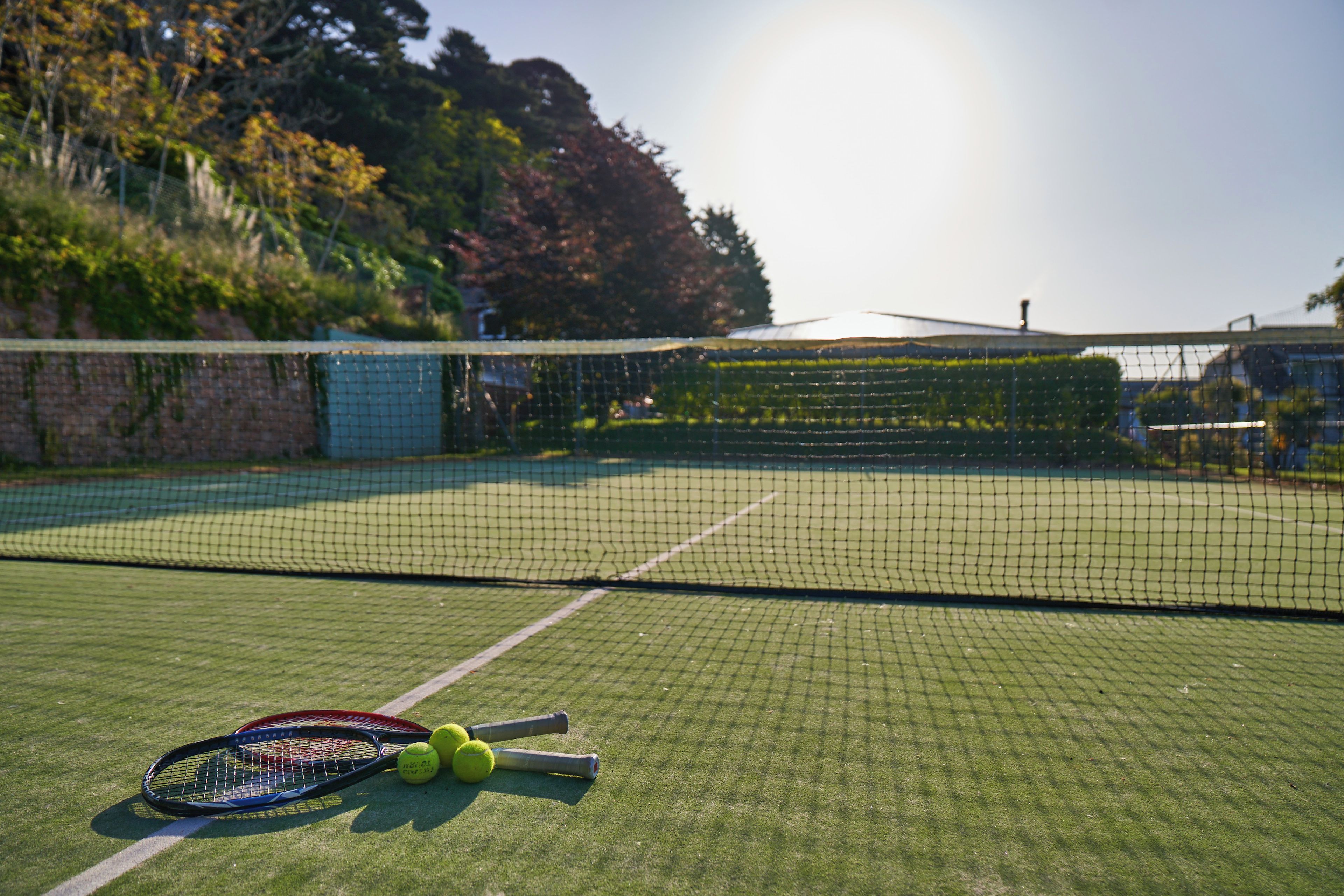 Un court de tennis avec un filet, des raquettes de tennis et des balles.