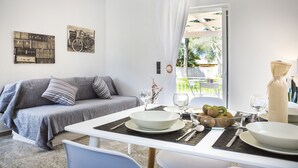 Un salon moderne avec un canapé, une table à manger et une vue sur l’extérieur.