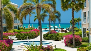 A resort with a pool, palm trees, and a view of the ocean. - Regal Beach Club (Seven Mile Beach)
