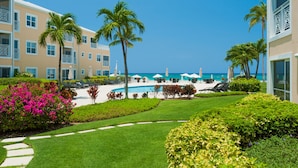 A resort with a pool, palm trees, and a view of the ocean. - Regal Beach Club (Seven Mile Beach)