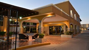Un hotel con entrada cubierta, zona de estar exterior y entrada porticada.