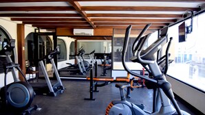 Un gimnasio con bicicletas estáticas, cintas de correr y equipo de ejercicio.