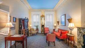 A room with a fireplace, a sofa, a chair, a table, and a bookshelf. - La Reserve on Pine (Philadelphia)