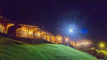 Vista frontal de la propiedad por la tarde o noche