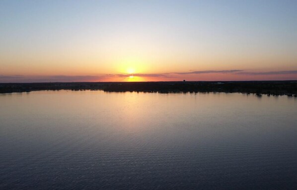 Un cuerpo de agua tranquila reflejando el atardecer.