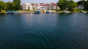 A waterfront hotel with multiple balconies, a dock with boats, and a well-maintained lawn. - Delavan Lake Resort (Delavan)