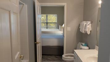 A compact bathroom with a toilet, sink, and a small window.