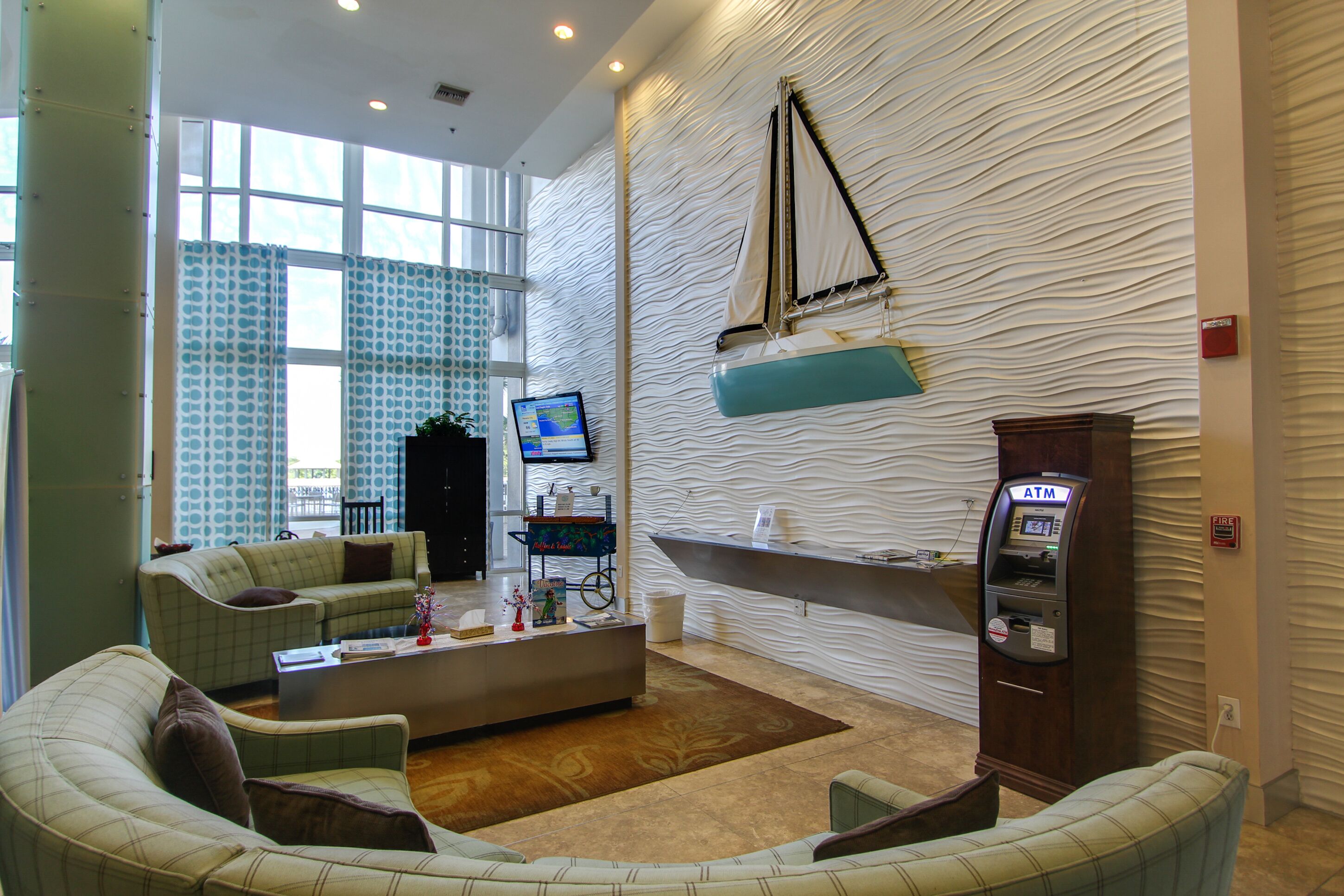 Eine moderne Lobby mit Empfangsschalter, Sitzgelegenheiten und einem Geldautomaten.