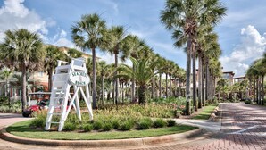 A sign for Seacrest Beach, surrounded by palm trees and a paved walkway. - Villas of Seacrest Beach on 30A by Panhandle Getaways (Panama City Beach)