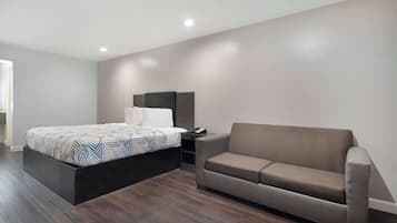 Une chambre à coucher moderne avec un lit, un canapé et une table de chevet.