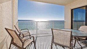 A balcony with a view of the ocean, furnished with wicker chairs and a table. - Regency Towers Beach Resort by Panhandle Getaways (Panama City Beach)