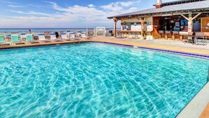 A clear blue pool with lounge chairs and a bar area. - Regency Towers Beach Resort by Panhandle Getaways (Panama City Beach)