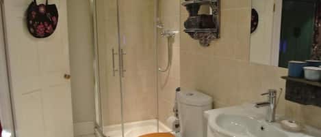 Un baño con ducha, inodoro y lavamanos.