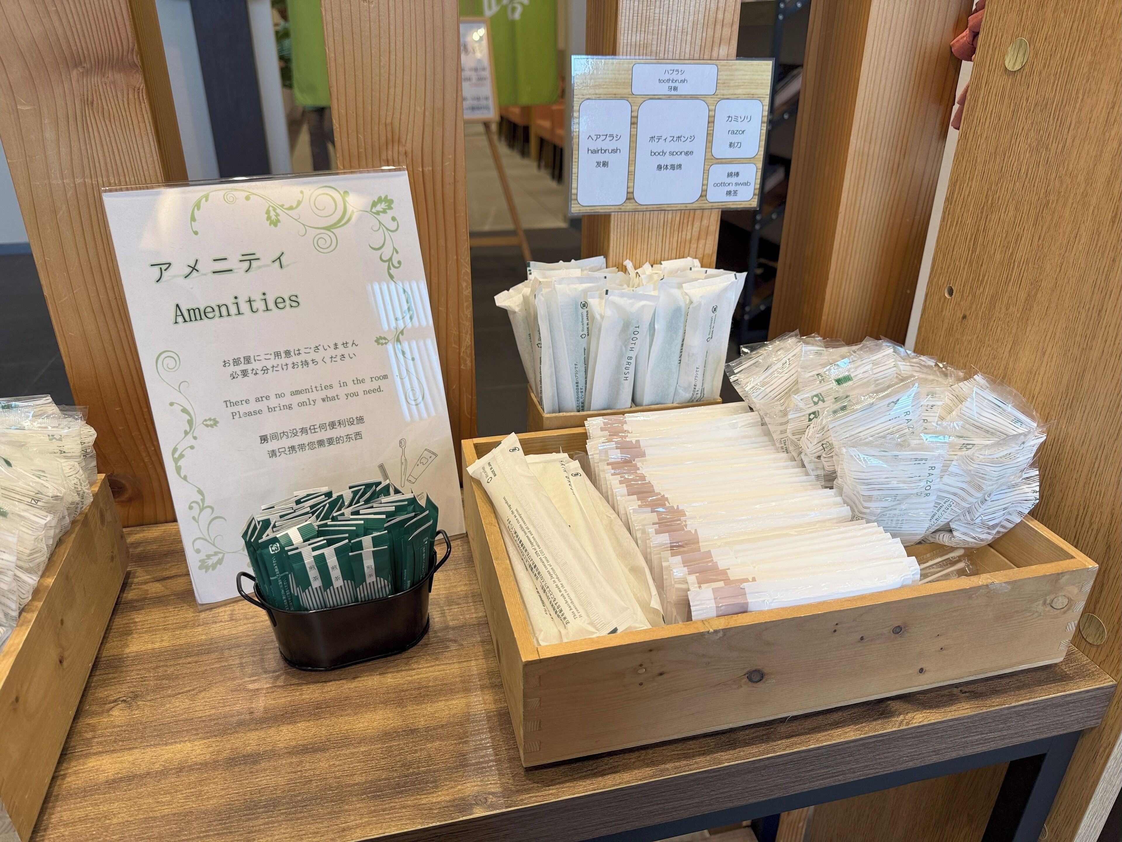 A wooden display with amenities including a sign labeled 'Amenities' and various toiletry items like toothbrushes and razors.