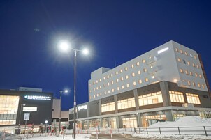 Un edificio moderno con varios pisos y amplios ventanales, rodeado de nieve.