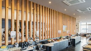 A modern buffet setup with wooden partitions, a variety of dishes, and a clean, well-lit environment.