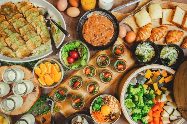 Variedad de alimentos como pan, huevos y verduras dispuestas sobre una mesa.