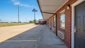 A Stay Inn with a covered parking area, brick exterior, and a visible truck in the background.