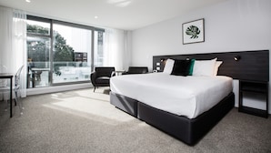 Een moderne hotelkamer met een groot bed, een bureau en een stoel.