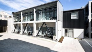Een modern gebouw met een glazen gevel en een donker exterieur.