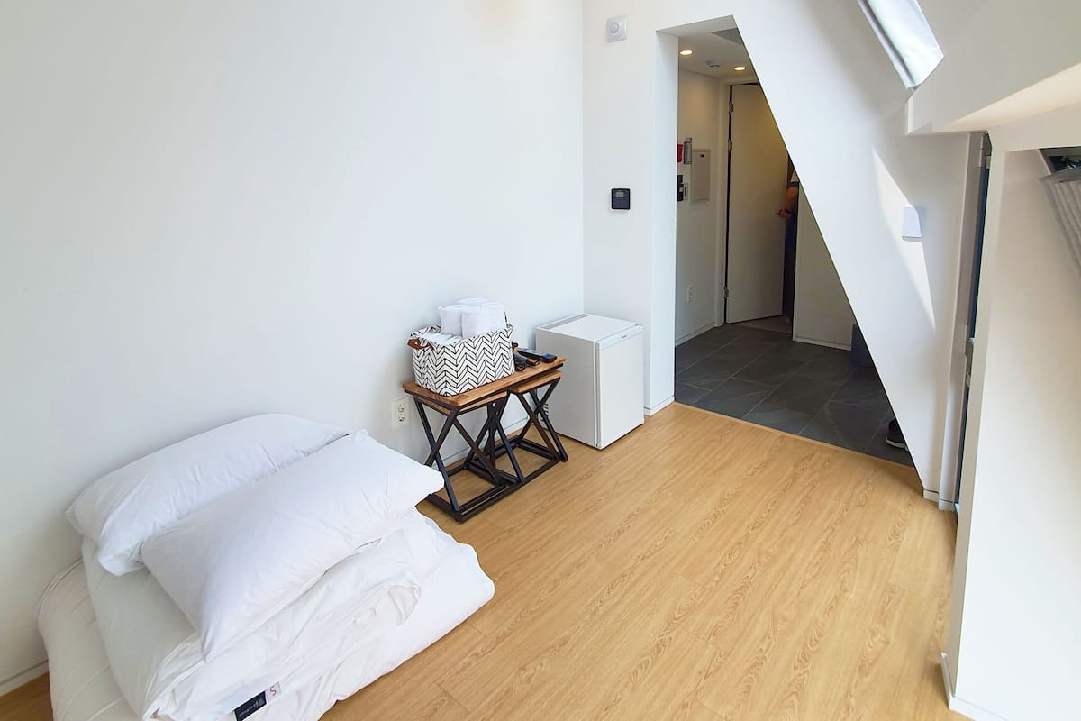 Una habitación moderna y minimalista con suelo de madera, paredes blancas y tragaluz.