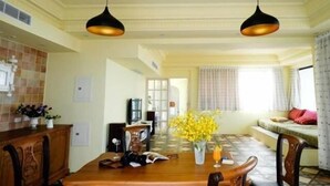A dining area with a wooden table, chairs, and hanging pendant lights. - 23.5 Blue B & B (Xiyu)