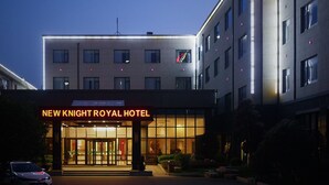 A hotel entrance with a sign reading "New Knight Royal Hotel." - New Knight Royal Hotel (Shanghai)