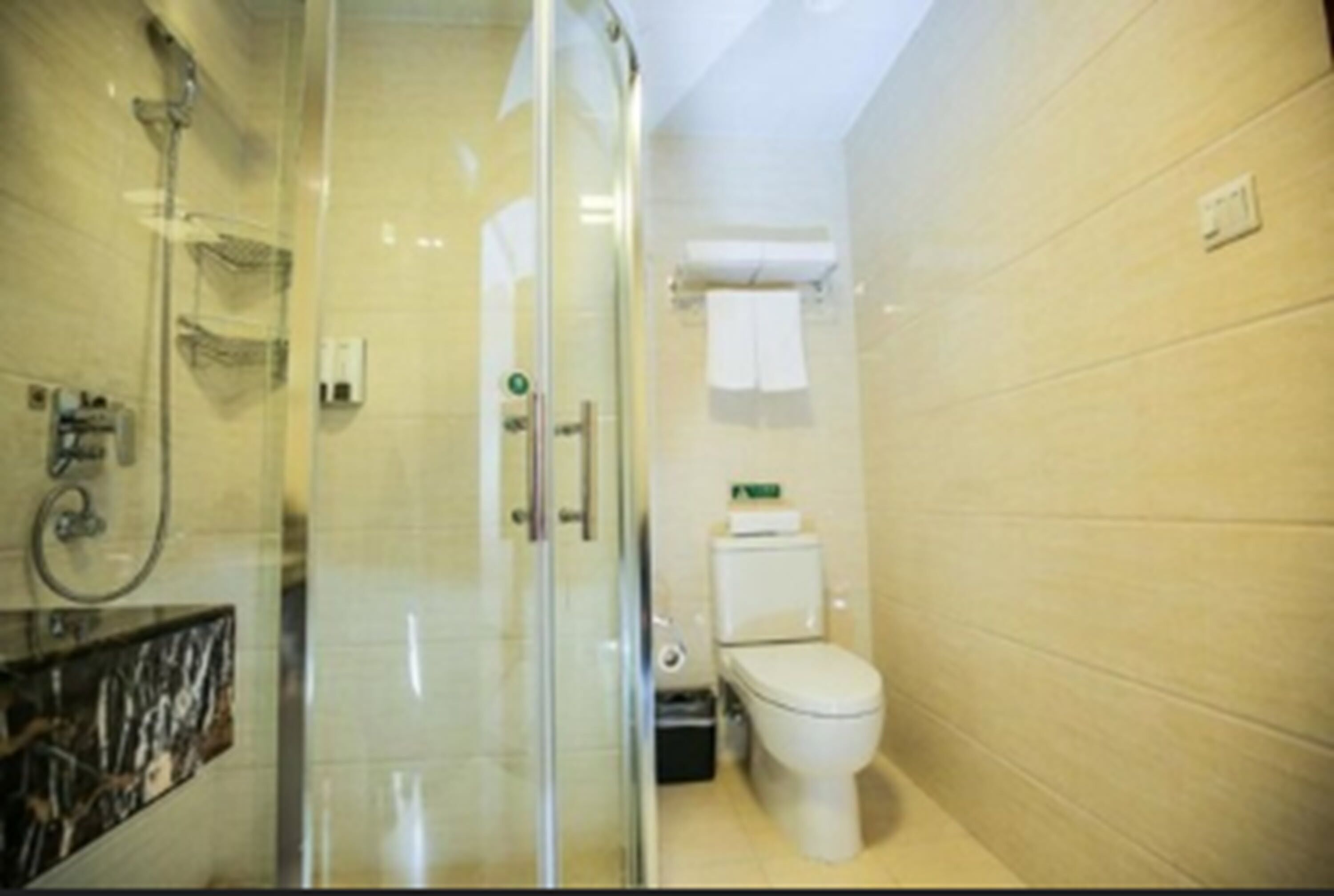 Un baño moderno con cabina de ducha de vidrio, inodoro y lavamanos.