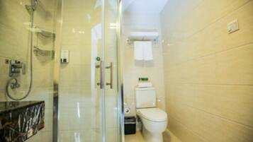 Un baño moderno con cabina de ducha de vidrio, inodoro y lavamanos.
