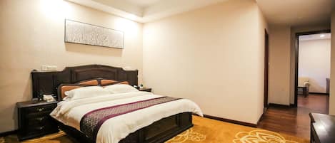 Una habitación de hotel con una cama grande, una mesita de noche, una obra de arte colgada en la pared y un suelo de madera con estampado floral.