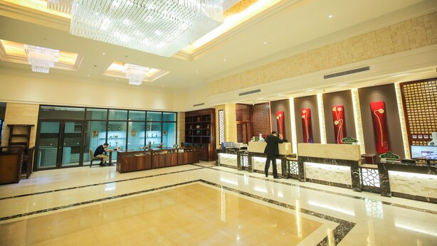 A spacious lobby with a marble floor, a reception desk, and a large chandelier. - New Knight Royal Hotel (Shanghai)