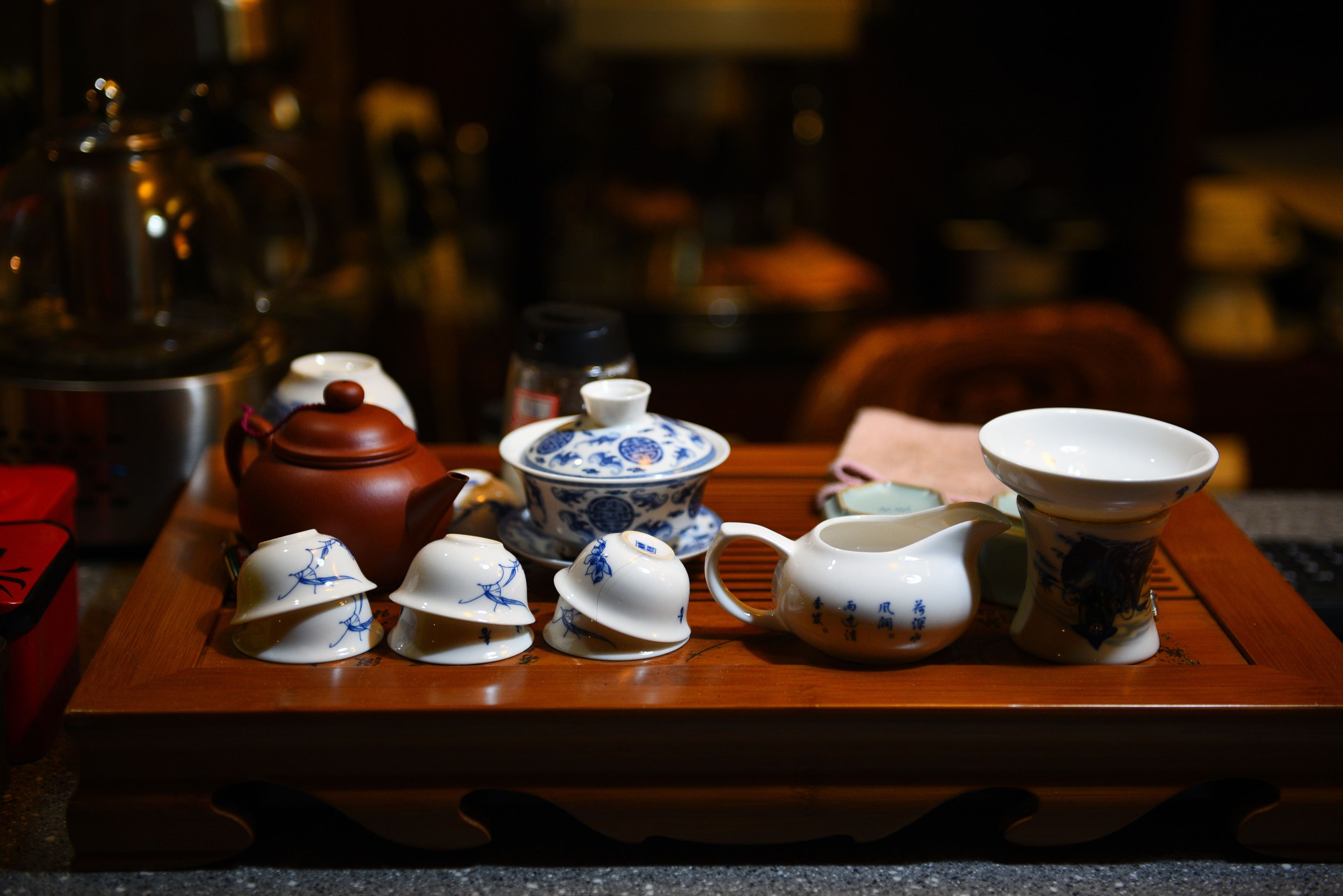 A tray with various tea utensils including teapots, cups, and a pitcher.