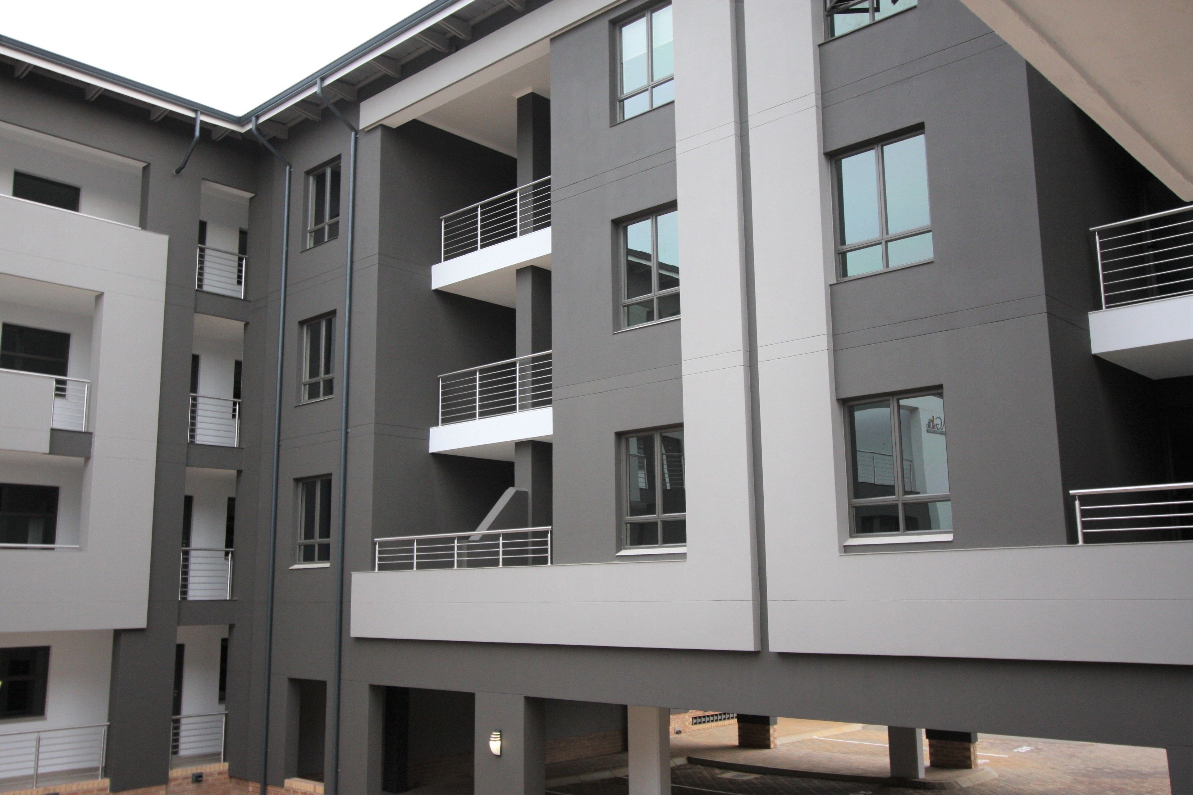 A multi-story building with balconies, large windows, and a modern architectural design.