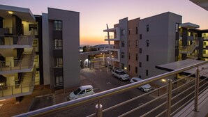 A modern multi-story building with a parking area and a staircase leading to the upper levels.