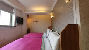 A hotel room with two beds, a window, a wall-mounted TV, and a coat rack. - Nice Hotel (Taipei)