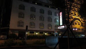 A multi-story hotel with a brick facade and multiple windows. - Nice Hotel (Taipei)
