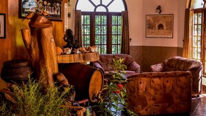 A rustic interior with wooden beams, a large wooden table, and comfortable seating. - MF Estate Holiday Bungalow (Hali-Ela)