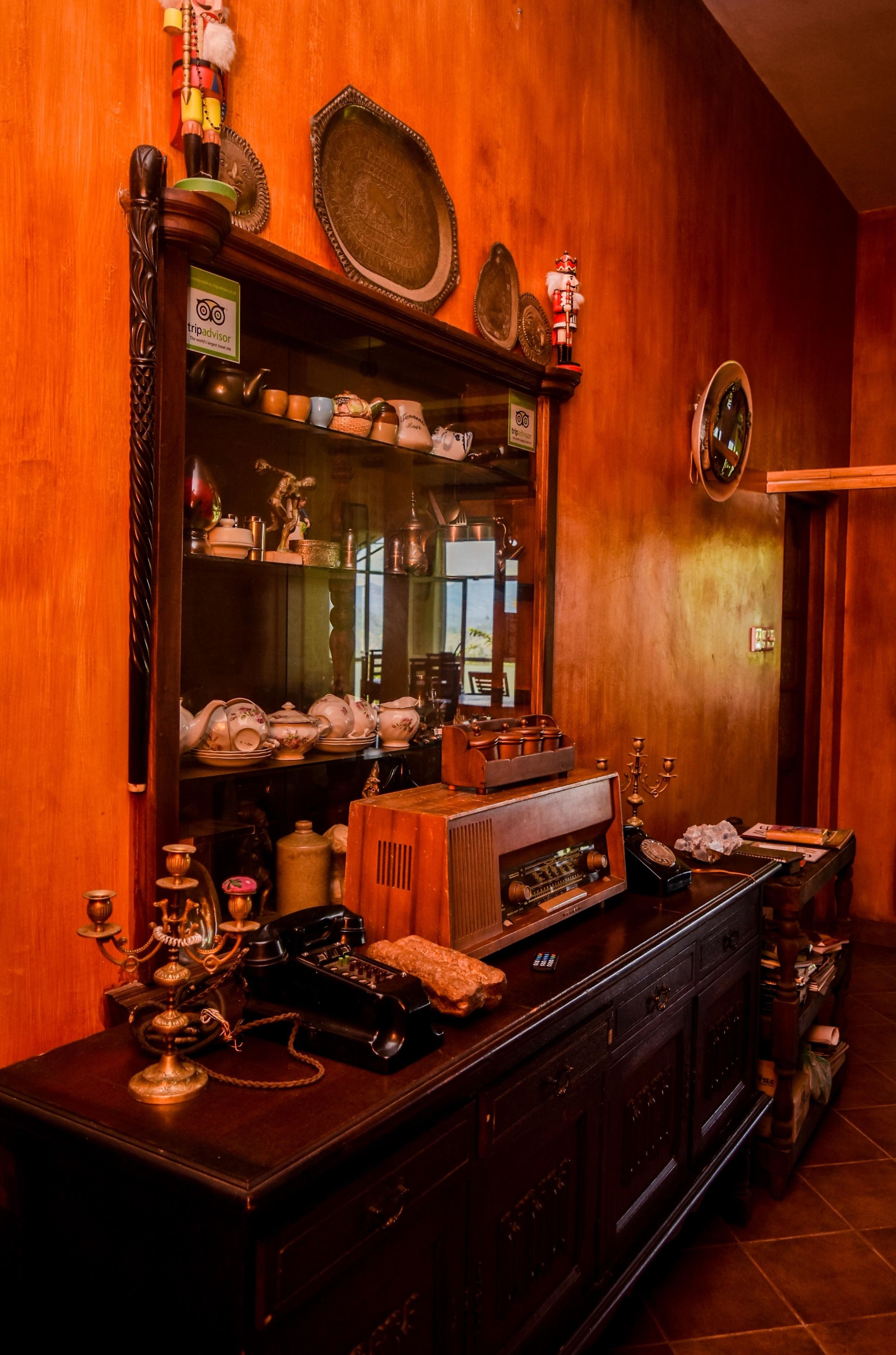A wooden interior with a large mirror, shelves with decorative items, and a vintage radio.