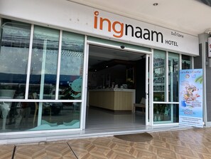 A hotel entrance with a reception desk, a glass door, and a sign advertising a 40% discount.