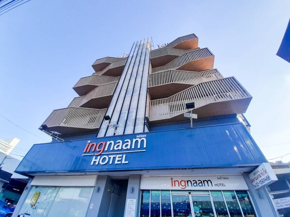 A hotel with a unique architectural design featuring multiple balconies and a prominent vertical structure.