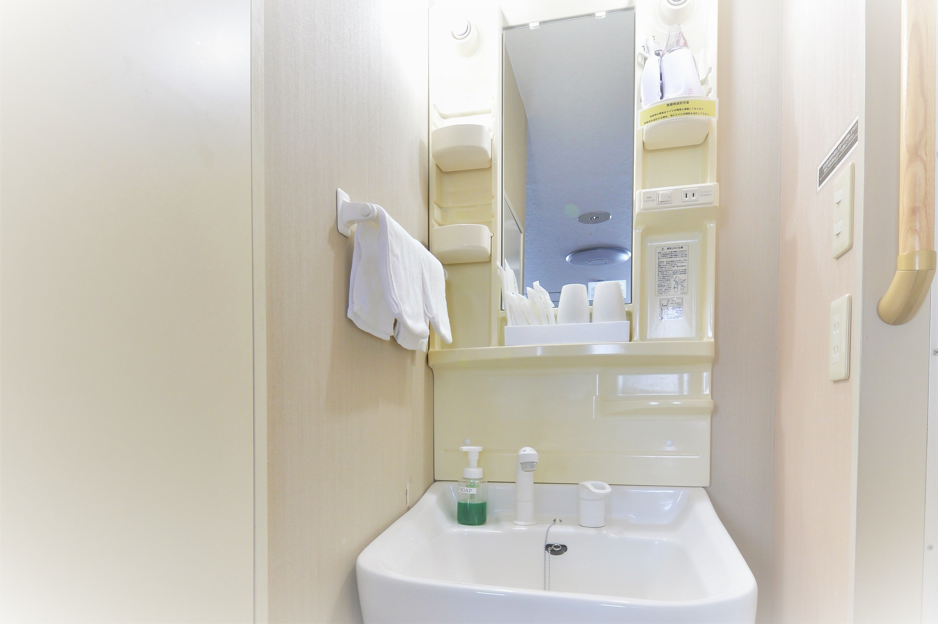 A bathroom with a sink, mirror, and toiletries.