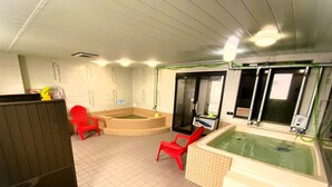 A room with a large bathtub, a small hot tub, and two red chairs. - A-Gate Hotel (Hakodate)